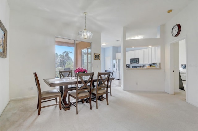 dining space with light colored carpet and an inviting chandelier