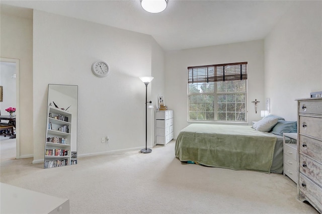 bedroom featuring light colored carpet and lofted ceiling