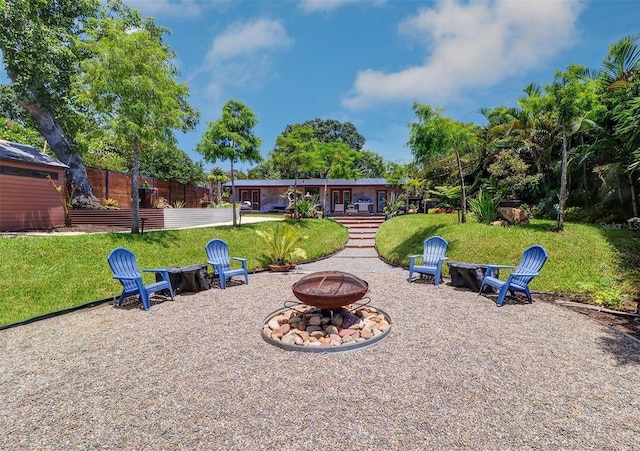 view of home's community with a yard and an outdoor fire pit