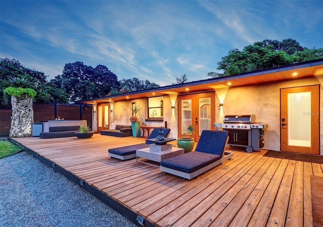 deck at dusk with french doors, area for grilling, and a hot tub