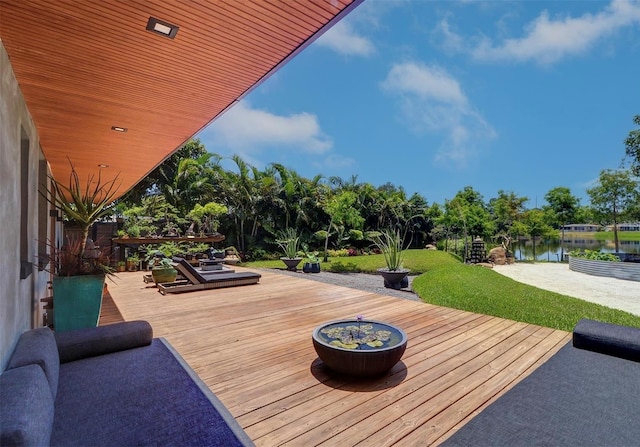 deck with a lawn and a water view