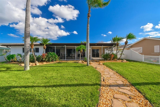 back of property with a sunroom and a yard