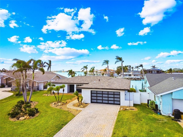 ranch-style home with a garage and a front lawn