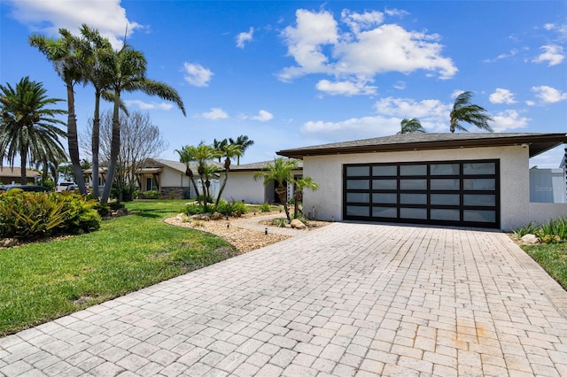 11683 Grove St, Seminole, FL 33772 - view of front of home featuring stucco siding, decorative driveway, a front yard, and a garage