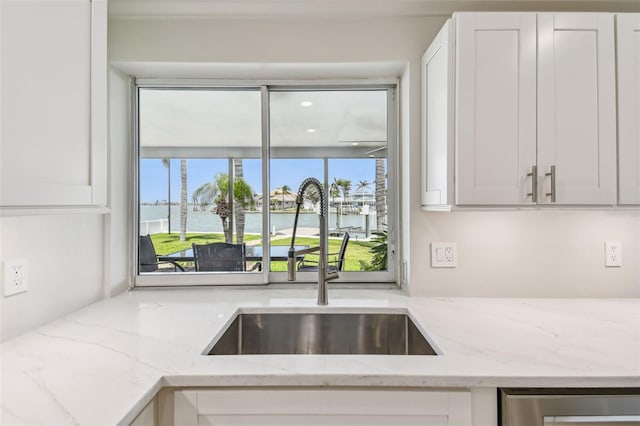 11683 Grove St, Seminole, FL 33772 - kitchen with a water view, white cabinets, light stone countertops, and dishwasher