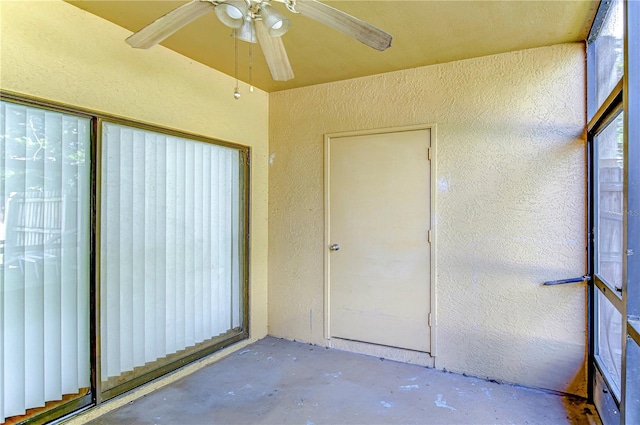 unfurnished sunroom featuring ceiling fan