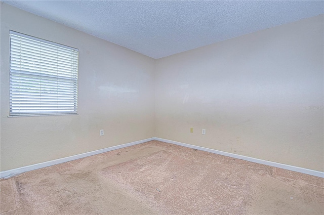 carpeted spare room featuring a textured ceiling