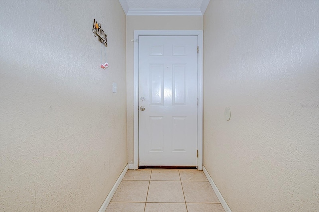 entryway with ornamental molding and light tile patterned flooring