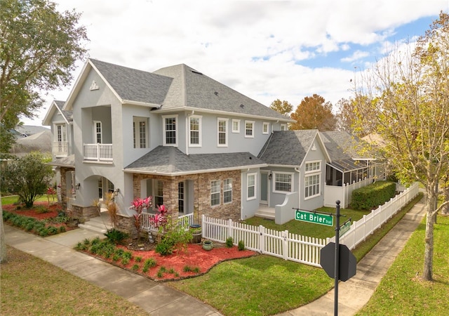 view of front of house with a balcony, a front lawn, and a porch