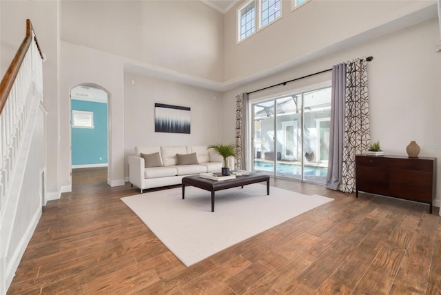 living room featuring dark hardwood / wood-style flooring and a towering ceiling