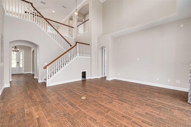 unfurnished living room with dark hardwood / wood-style floors and a high ceiling