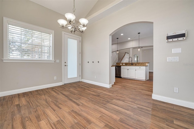 interior space featuring wood-type flooring, lofted ceiling, a notable chandelier, and sink