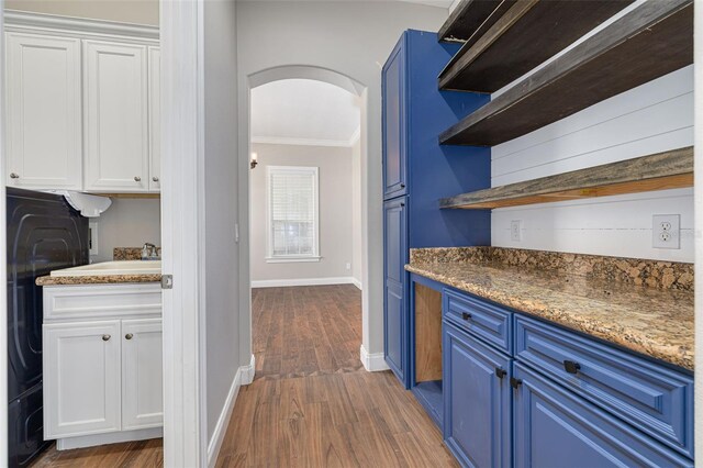 kitchen featuring dark hardwood / wood-style flooring, white cabinetry, blue cabinets, and crown molding