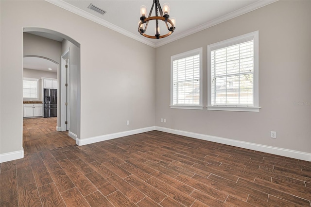 spare room featuring a notable chandelier, dark hardwood / wood-style floors, and crown molding