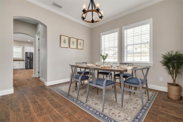 dining space featuring ornamental molding, dark wood-type flooring, and a chandelier