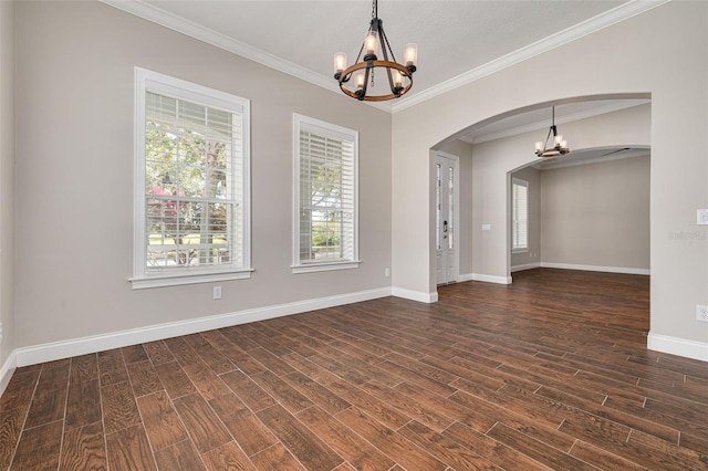 unfurnished room with a chandelier, ornamental molding, plenty of natural light, and dark wood-type flooring