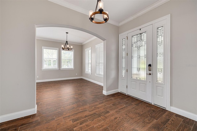 foyer featuring an inviting chandelier, dark wood-type flooring, and crown molding