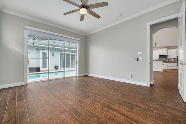 empty room with dark hardwood / wood-style flooring, ceiling fan, and crown molding