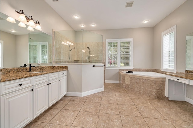 bathroom with tile patterned flooring, vanity, a healthy amount of sunlight, and plus walk in shower