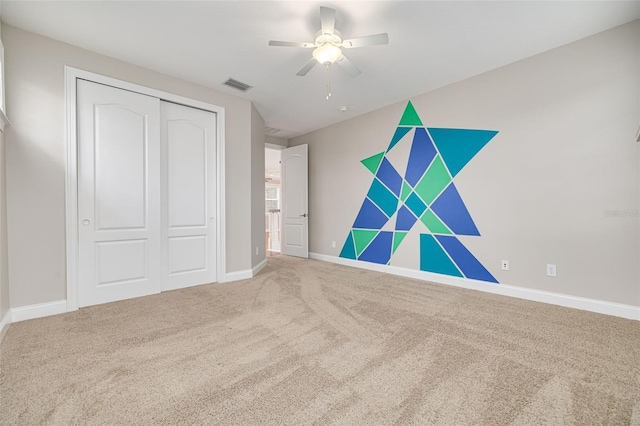 unfurnished bedroom featuring carpet, ceiling fan, and a closet