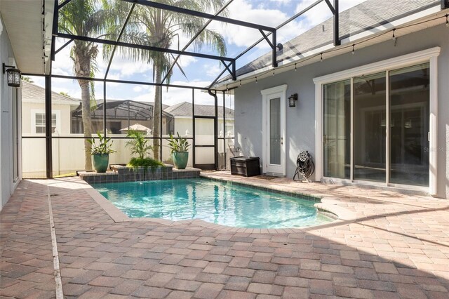 view of swimming pool with glass enclosure and a patio area