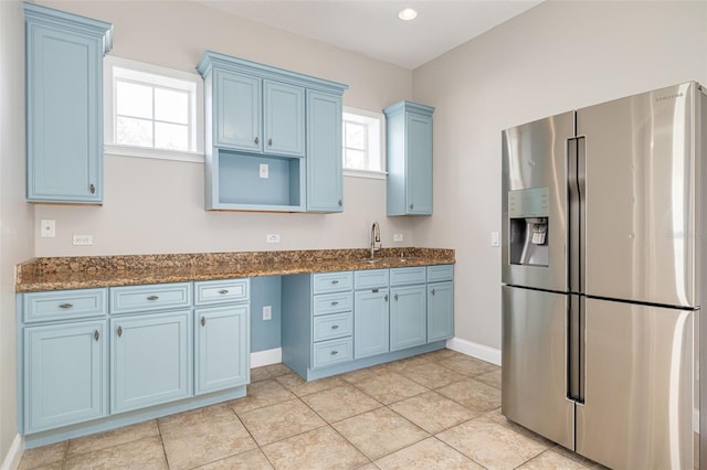 kitchen with stainless steel fridge with ice dispenser, blue cabinets, a healthy amount of sunlight, and sink