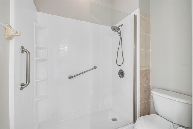 bathroom with toilet and a tile shower