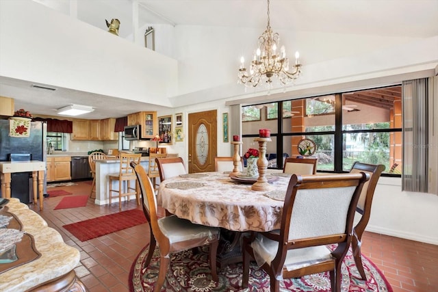 dining room featuring brick floor, a chandelier, visible vents, and high vaulted ceiling