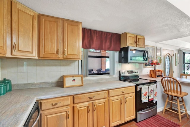 kitchen featuring appliances with stainless steel finishes, light countertops, backsplash, and a textured ceiling