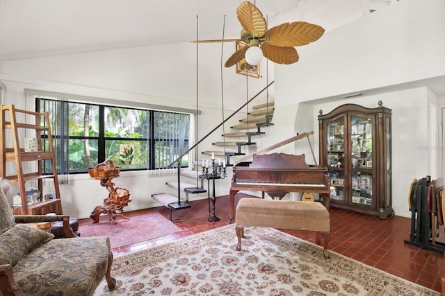 living room with brick floor, high vaulted ceiling, stairway, and ceiling fan