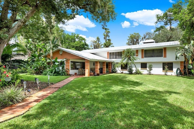 rear view of house featuring stucco siding and a yard