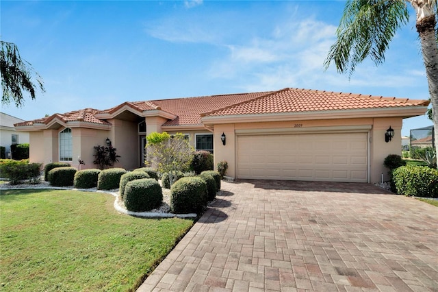 mediterranean / spanish house with a front yard and a garage