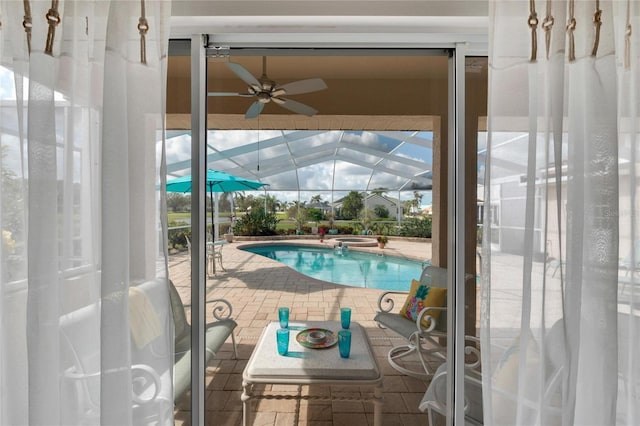 view of swimming pool featuring a patio, ceiling fan, and a lanai