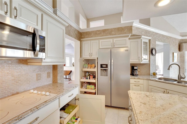 kitchen featuring light stone countertops, sink, light tile patterned floors, and appliances with stainless steel finishes