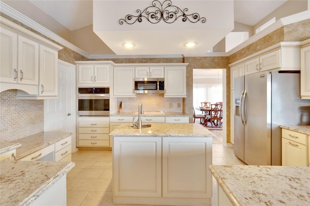 kitchen with light stone countertops, ornamental molding, light tile patterned flooring, white cabinetry, and stainless steel appliances