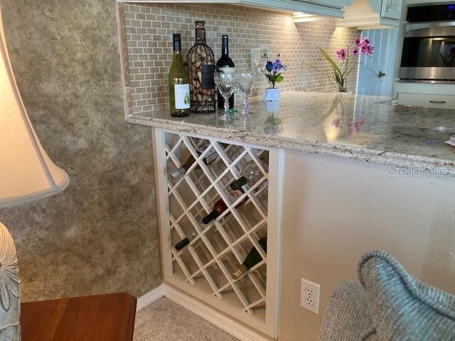 interior space featuring decorative backsplash, light stone countertops, and double oven