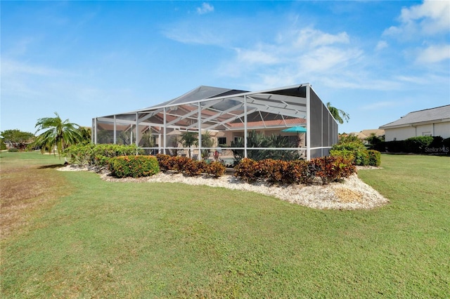 rear view of property featuring a lanai and a yard