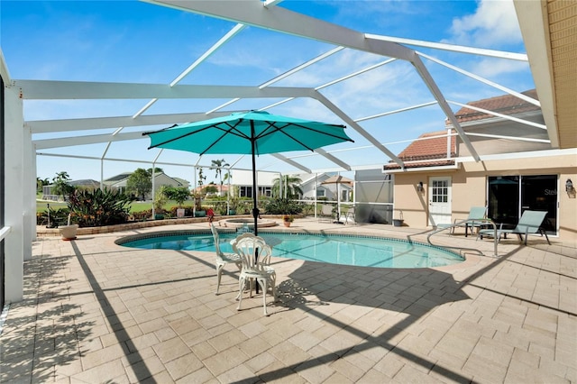 view of pool featuring glass enclosure, a patio area, and an in ground hot tub