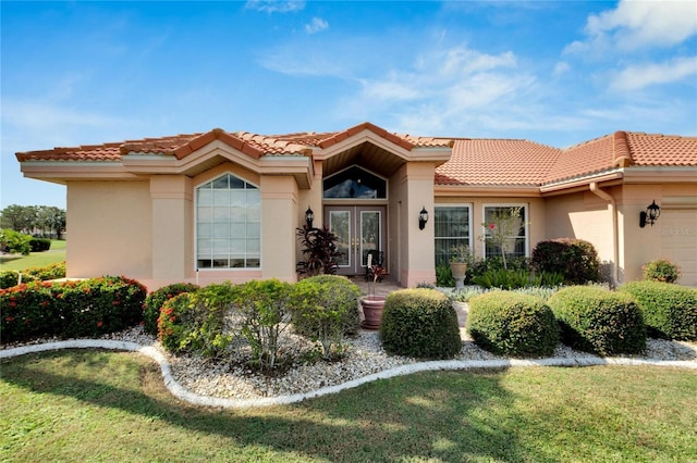 mediterranean / spanish-style home featuring french doors and a front lawn