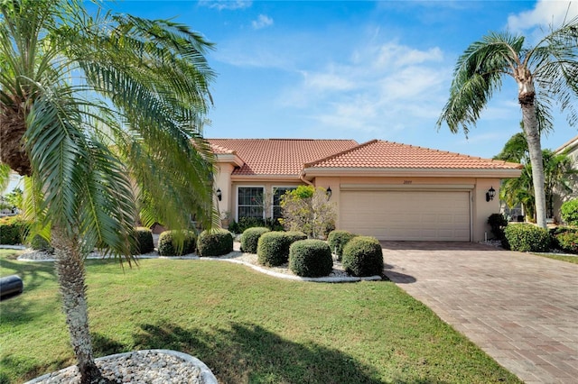 mediterranean / spanish-style home with a front yard and a garage