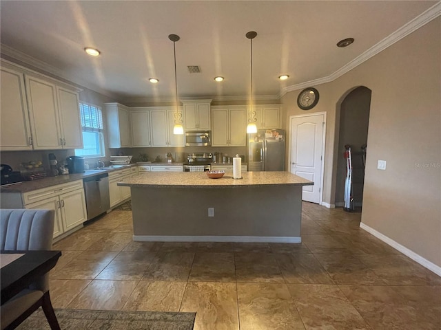 kitchen featuring crown molding, stainless steel appliances, a kitchen island, pendant lighting, and white cabinets