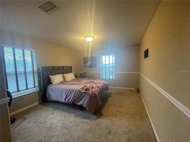 bedroom with carpet flooring, multiple windows, and vaulted ceiling