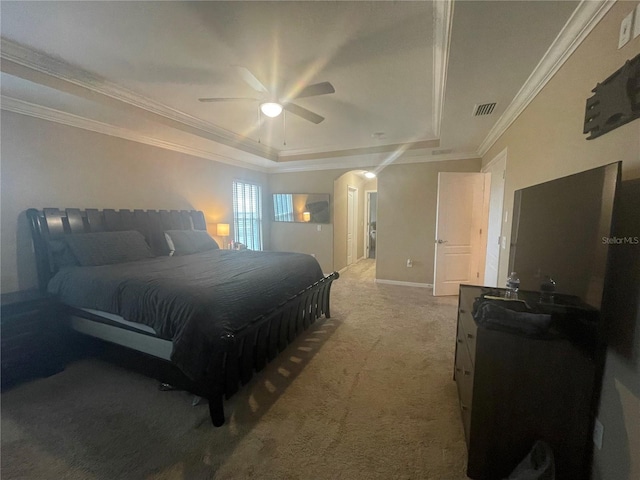 carpeted bedroom featuring ornamental molding, ceiling fan, and a tray ceiling