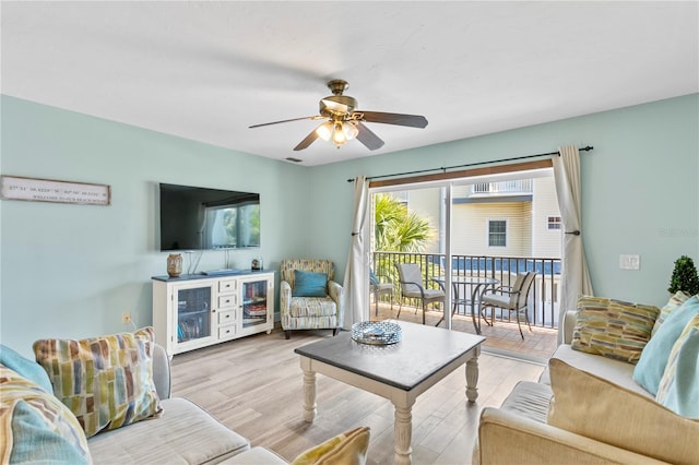 living room featuring ceiling fan and light hardwood / wood-style floors