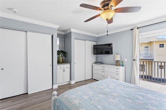 19807 Gulf Blvd Unit 128, Indian Shores, FL 33785 - bedroom featuring multiple closets, wood finished floors, crown molding, and a ceiling fan