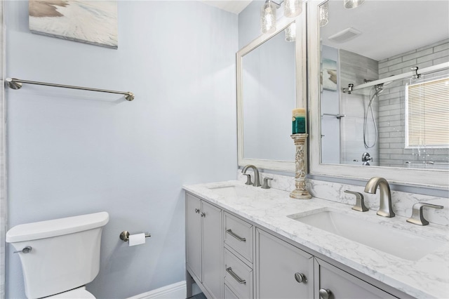 bathroom featuring vanity, toilet, and a shower with shower door