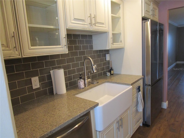 kitchen with tasteful backsplash, stainless steel fridge, light stone counters, and dark hardwood / wood-style floors