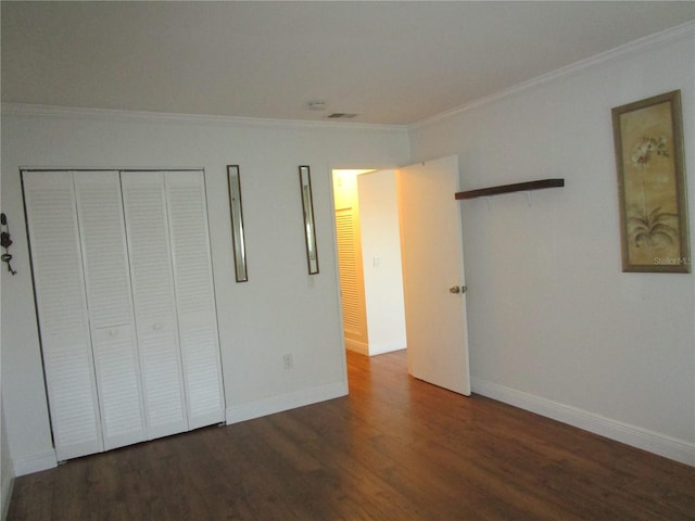 unfurnished bedroom with dark hardwood / wood-style flooring, a closet, and crown molding