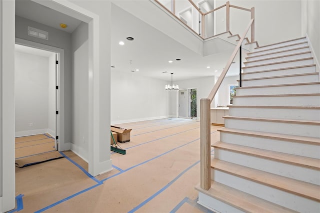 stairs with an inviting chandelier