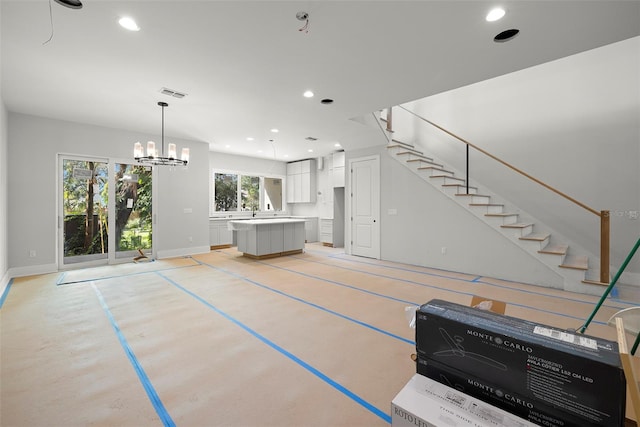 unfurnished living room with a wealth of natural light and a notable chandelier